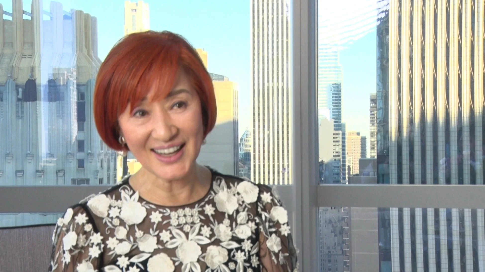 窓越しに都市風景を望む女性